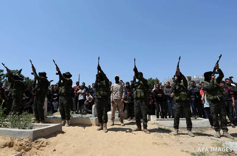 Palestinian militants from the Al-Quds Brigades, the armed wing of the Islamic Jihad movement attend the funeral of their comrades who were killed in an explosion in the previous day, in Rafah in the southern Gaza Strip...