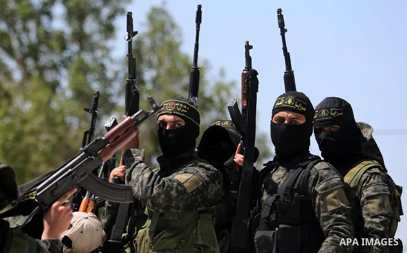Palestinian militants from the Al-Quds Brigades, the armed wing of the Islamic Jihad movement attend the funeral of their comrades who were killed in an explosion in the previous day, in Rafah in the southern Gaza Strip...