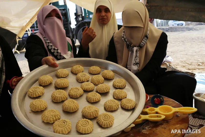 Palestinian women prepare traditional date-filled mini cakes during a tent city protest along Israel border with Gaza, demanding to return to their home land, east of Gaza City, April 16, 2018. Photo by Yasser Qudih