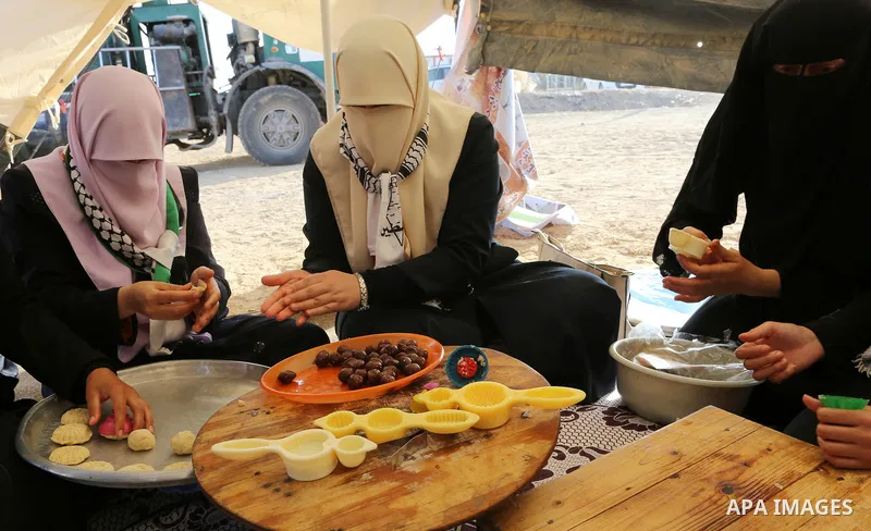 Palestinian women prepare traditional date-filled mini cakes during a tent city protest along Israel border with Gaza, demanding to return to their home land, east of Gaza City, April 16, 2018. Photo by Yasser Qudih
