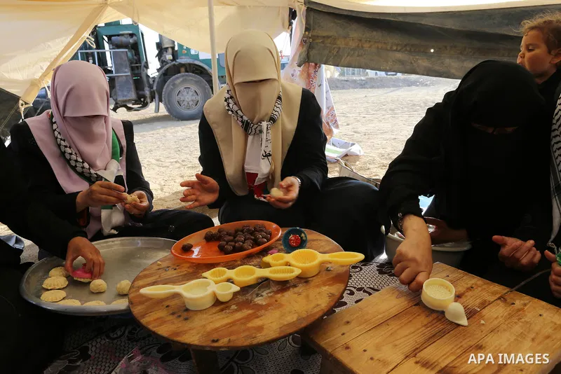 Palestinian women prepare traditional date-filled mini cakes during a tent city protest along Israel border with Gaza, demanding to return to their home land, east of Gaza City, April 16, 2018. Photo by Yasser Qudih