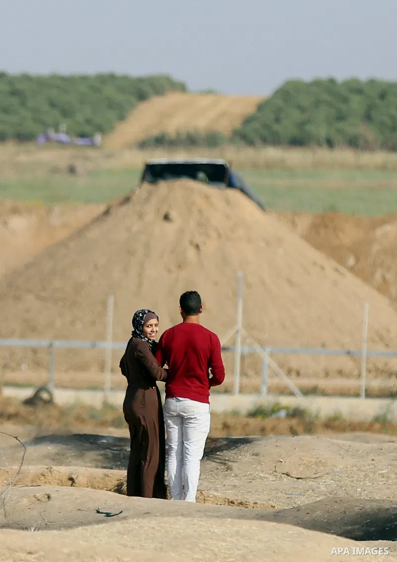 Palestinians walk near Israel border with Gaza, during a tent city protest demanding to return to their home land, east of Gaza City, April 16, 2018. Photo by Yasser Qudih