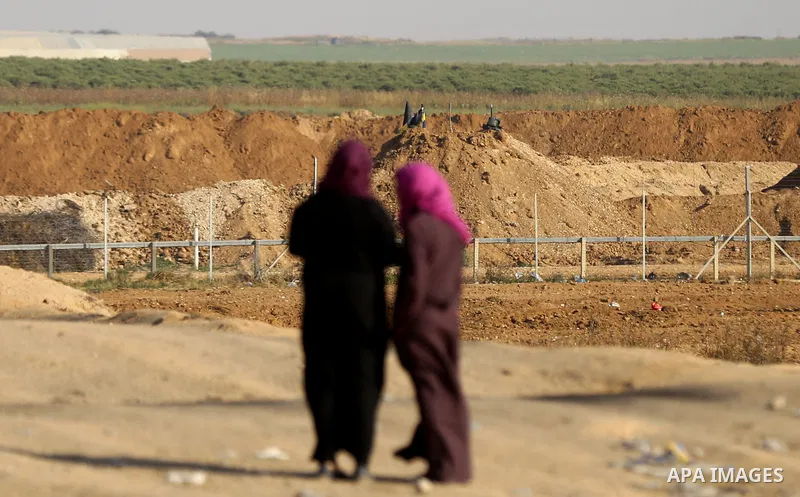 Palestinians walk near Israel border with Gaza, during a tent city protest demanding to return to their home land, east of Gaza City, April 16, 2018. Photo by Yasser Qudih