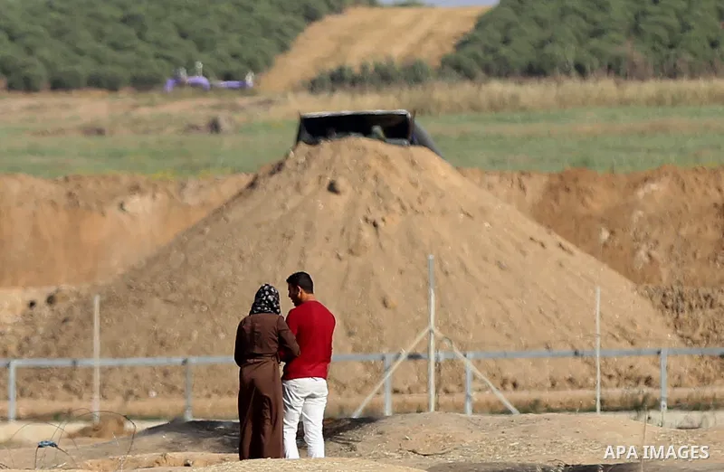 Palestinians walk near Israel border with Gaza, during a tent city protest demanding to return to their home land, east of Gaza City, April 16, 2018. Photo by Yasser Qudih