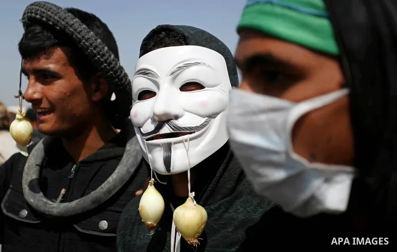 A picture taken on April 6, 2018, show Palestinian protesters cover their faces to protect themselves from tear gas during clashes with Israeli security forces following a protest, on the Gaza-Israel border, in Khan Youn...