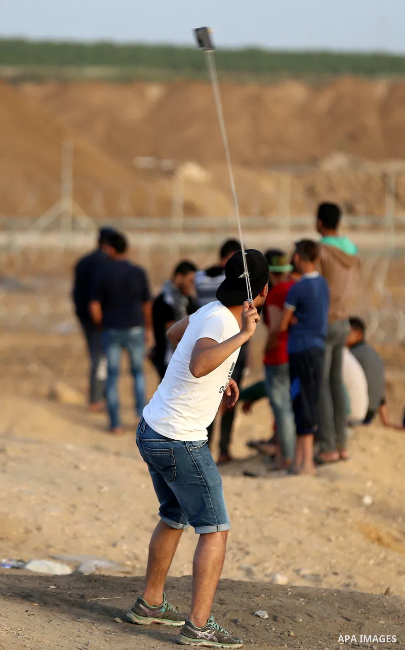 Palestinians gather during clashes with Israeli security forces in a tent city protest along Israel border with Gaza, demanding to return to their homeland, east of Gaza City, April 18, 2018. Photo by Yasser Qudih