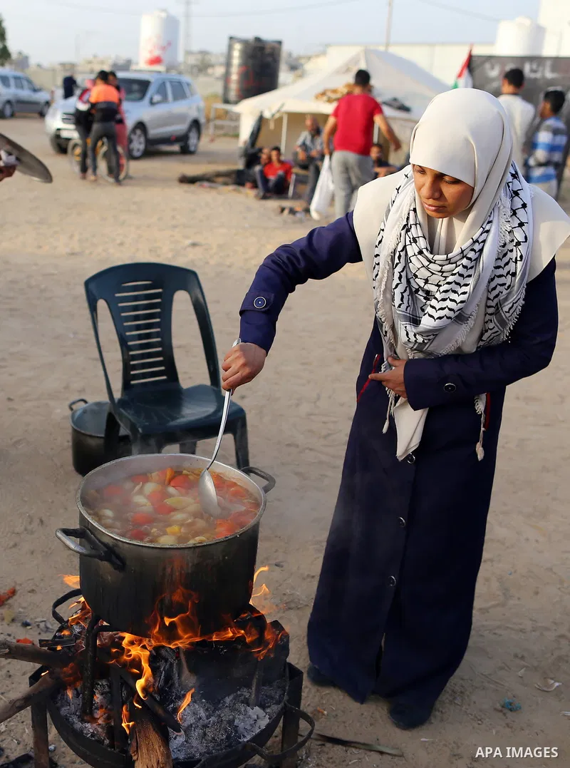 Palestinian women prepare Couscous during a tent city protest along Israel border with Gaza, demanding to return to their homeland, east of Gaza City, April 18, 2018. Photo by Yasser Qudih