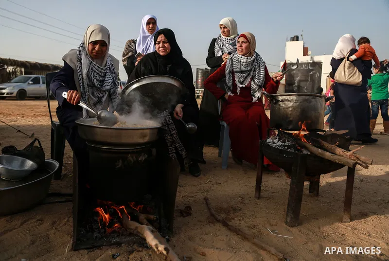 Palestinian women prepare Couscous during a tent city protest along Israel border with Gaza, demanding to return to their homeland, east of Gaza City, April 18, 2018. Photo by Mohammed Dahman