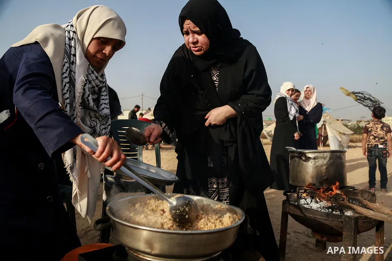 Palestinian women prepare Couscous during a tent city protest along Israel border with Gaza, demanding to return to their homeland, east of Gaza City, April 18, 2018. Photo by Mohammed Dahman