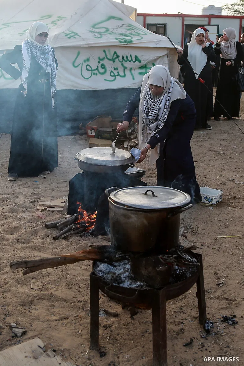 Palestinian women prepare Couscous during a tent city protest along Israel border with Gaza, demanding to return to their homeland, east of Gaza City, April 18, 2018. Photo by Mohammed Dahman