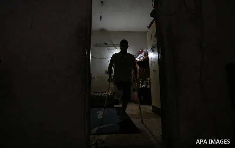 Palestinian cyclist Alaa Al-Daly, 21, who lost his leg by a bullet fired by Israeli troops along the Gaza border during a protest, walks using crutches at his home in Rafah in the southern Gaza Strip on April 19, 2018. D...