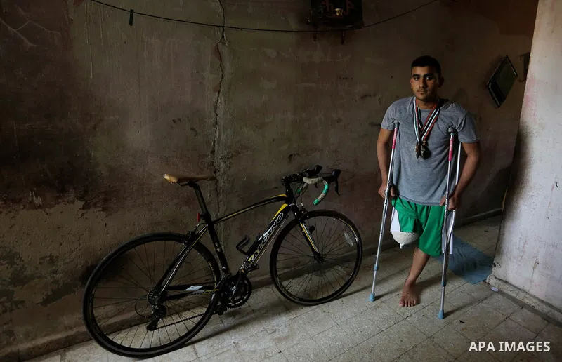 Palestinian cyclist Alaa Al-Daly, 21, who lost his leg by a bullet fired by Israeli troops along the Gaza border during a protest, stands next to his bicycle, at his home in Rafah in the southern Gaza Strip on April 19,...