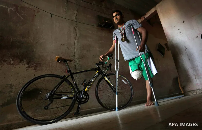 Palestinian cyclist Alaa Al-Daly, 21, who lost his leg by a bullet fired by Israeli troops along the Gaza border during a protest, stands next to his bicycle, at his home in Rafah in the southern Gaza Strip on April 19,...