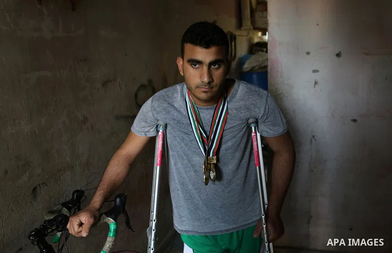 Palestinian cyclist Alaa Al-Daly, 21, who lost his leg by a bullet fired by Israeli troops along the Gaza border during a protest, stands next to his bicycle, at his home in Rafah in the southern Gaza Strip on April 19,...