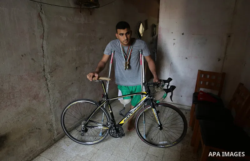 Palestinian cyclist Alaa Al-Daly, 21, who lost his leg by a bullet fired by Israeli troops along the Gaza border during a protest, stands next to his bicycle, at his home in Rafah in the southern Gaza Strip on April 19,...