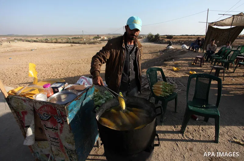 A Palestinian vendor sells corn during a protest at the Israel-Gaza border where Palestinians demand the right to return to their homeland, east of Gaza City April 19, 2018. Photo by Mahmoud Ajour