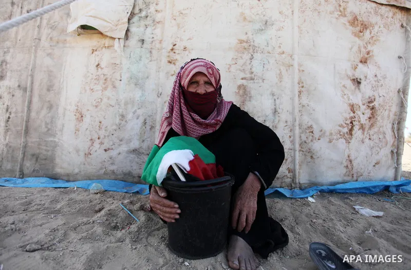 An elderly Palestinian woman sits next to a tent during a protest at the Israel-Gaza border where Palestinians demand the right to return to their homeland, east of Gaza City April 19, 2018. Photo by Mahmoud Ajour