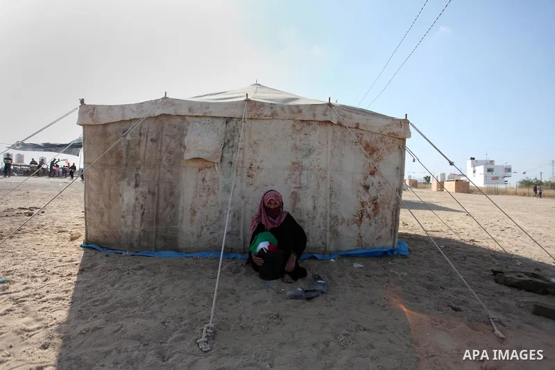 An elderly Palestinian woman sits next to a tent during a protest at the Israel-Gaza border where Palestinians demand the right to return to their homeland, east of Gaza City April 19, 2018. Photo by Mahmoud Ajour