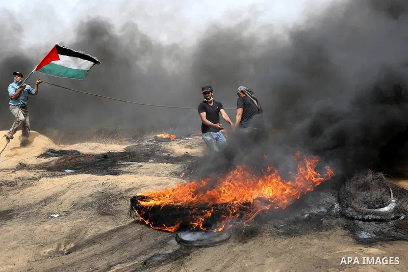 Palestinian protesters burn tires during clashes with Israeli security forces at tents protest at the Israel-Gaza border where Palestinians demand the right to return to their homeland, in Khan Younis in the southern Gaz...