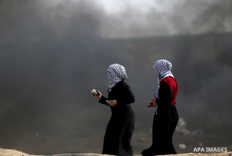 Palestinian women take part during clashes with Israeli security forces at tents protest at the Israel-Gaza border where Palestinians demand the right to return to their homeland, in east of Gaza city on April 20, 2018....