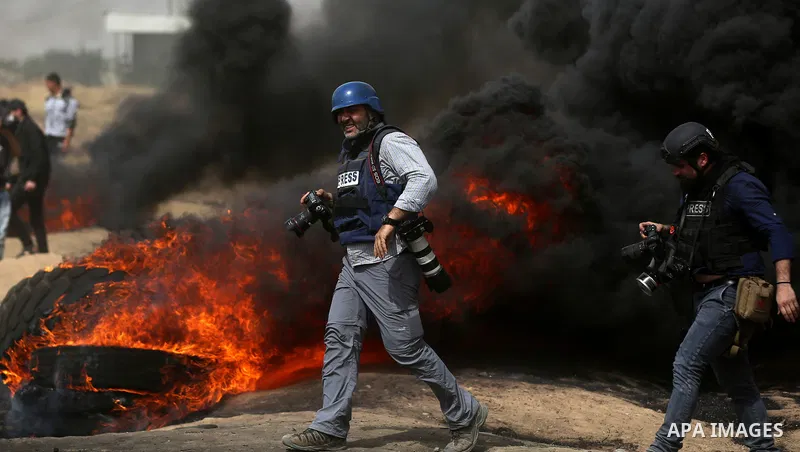 A Palestinian photographer takes photo during clashes between Palestinian protesters and Israeli security forces at tents protest at the Israel-Gaza border where Palestinians demand the right to return to their homeland,...