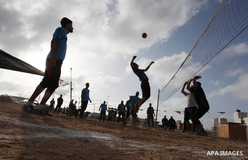Palestinians play volleyball near tents during a tent city protest demanding the right to return to their homeland, at the Israel-Gaza border in the east of Gaza city on April 21, 2018. Photo by Mahmoud Ajjour