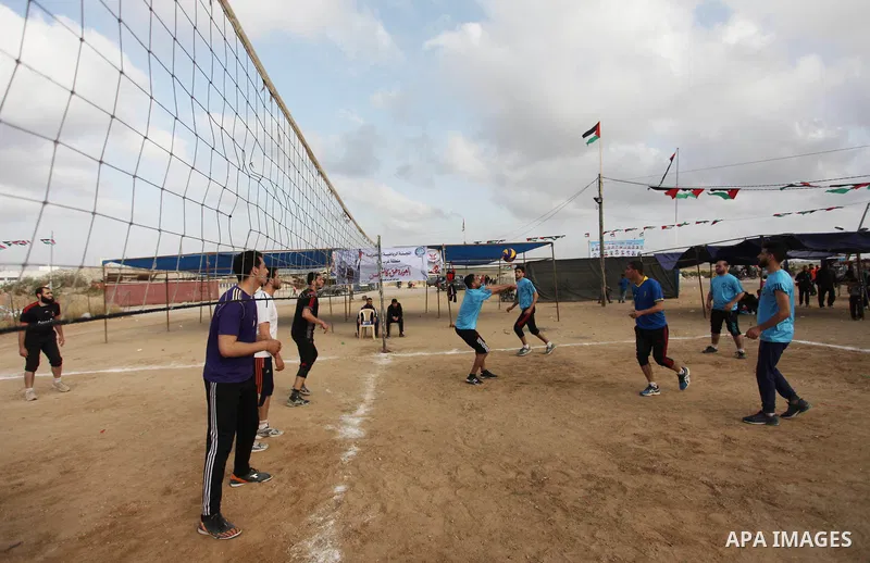 Palestinians play volleyball near tents during a tent city protest demanding the right to return to their homeland, at the Israel-Gaza border in the east of Gaza city on April 21, 2018. Photo by Mahmoud Ajjour