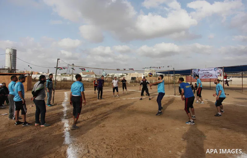 Palestinians play volleyball near tents during a tent city protest demanding the right to return to their homeland, at the Israel-Gaza border in the east of Gaza city on April 21, 2018. Photo by Mahmoud Ajjour