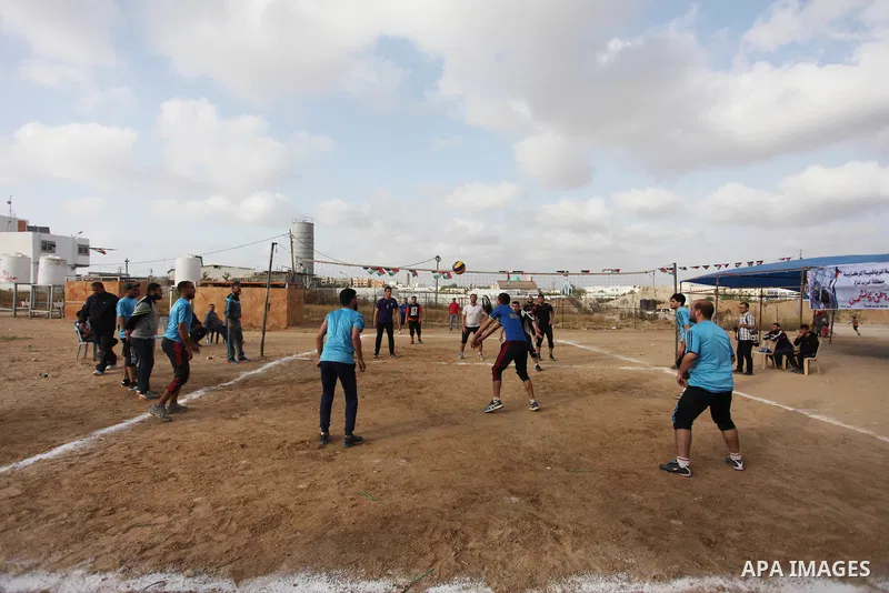 Palestinians play volleyball near tents during a tent city protest demanding the right to return to their homeland, at the Israel-Gaza border in the east of Gaza city on April 21, 2018. Photo by Mahmoud Ajjour