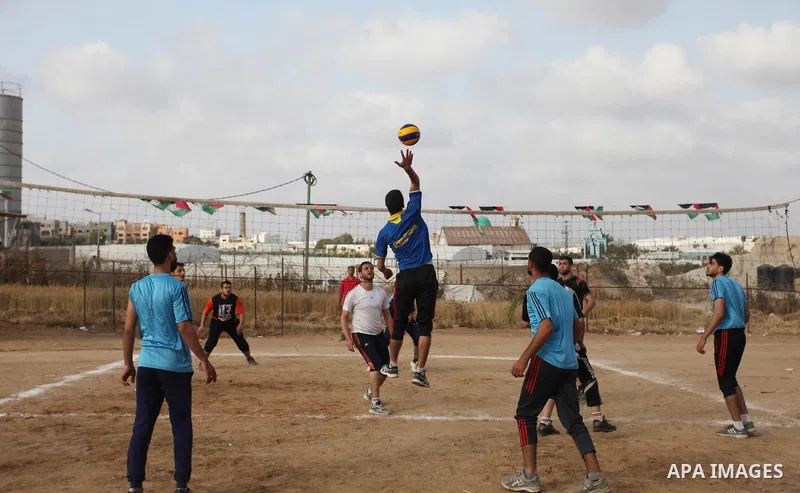 Palestinians play volleyball near tents during a tent city protest demanding the right to return to their homeland, at the Israel-Gaza border in the east of Gaza city on April 21, 2018. Photo by Mahmoud Ajjour