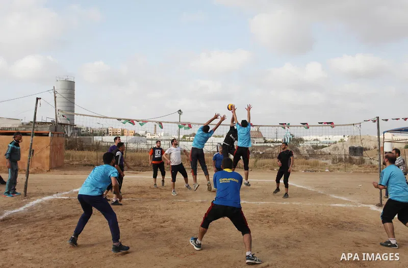 Palestinians play volleyball near tents during a tent city protest demanding the right to return to their homeland, at the Israel-Gaza border in the east of Gaza city on April 21, 2018. Photo by Mahmoud Ajjour