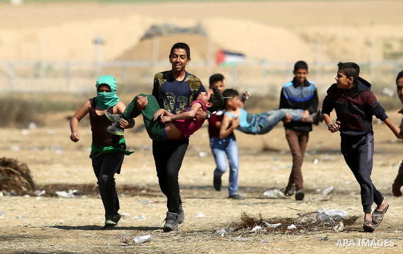 A wounded Palestinian boy is evacuated during clashes with Israeli security forces near the border fence with Israel near the southern Gaza Strip town of Khan Yunis during ongoing demonstrations on the Gaza-Israel border...