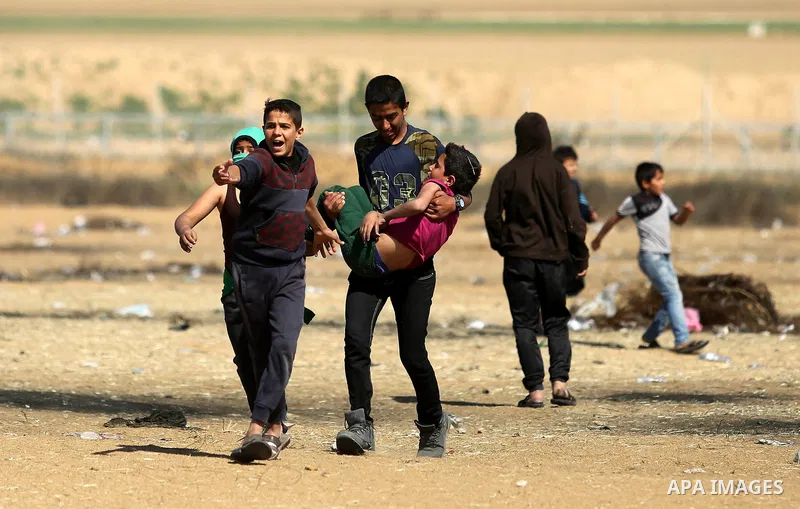 A wounded Palestinian boy is evacuated during clashes with Israeli security forces near the border fence with Israel near the southern Gaza Strip town of Khan Yunis during ongoing demonstrations on the Gaza-Israel border...