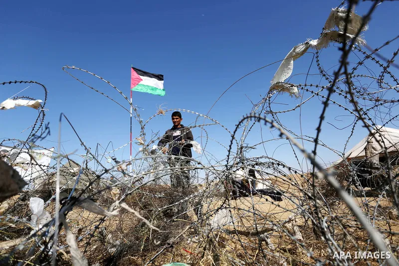 Palestinian protesters try to pull down part of the border fence with Israel near the southern Gaza Strip town of Khan Yunis during ongoing protests on the Gaza-Israel border on April 22, 2018. Photo by Ashraf Amra