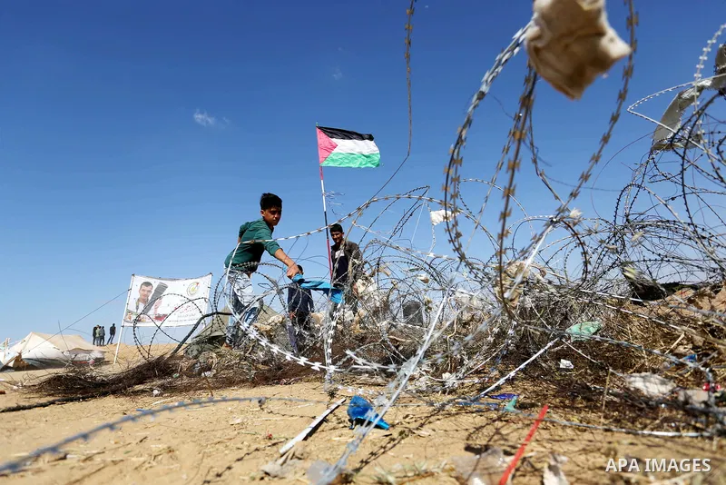 Palestinian protesters try to pull down part of the border fence with Israel near the southern Gaza Strip town of Khan Yunis during ongoing protests on the Gaza-Israel border on April 22, 2018. Photo by Ashraf Amra