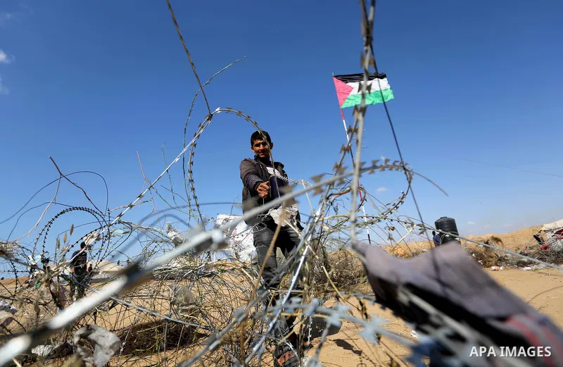 Palestinian protesters try to pull down part of the border fence with Israel near the southern Gaza Strip town of Khan Yunis during ongoing protests on the Gaza-Israel border on April 22, 2018. Photo by Ashraf Amra