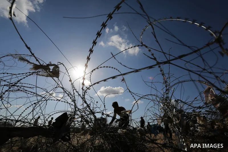 Palestinian protesters try to pull down part of the border fence with Israel near the southern Gaza Strip town of Khan Yunis during ongoing protests on the Gaza-Israel border on April 22, 2018. Photo by Ashraf Amra