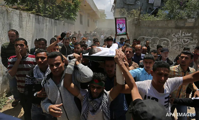 Mourners carry the body of a Palestinian deaf Tahreer Wahba, 18, who was died of from his injuries after being shot in the head by Israeli security forces during clashes on April 6, during his funeral in Khan Yunis, in t...
