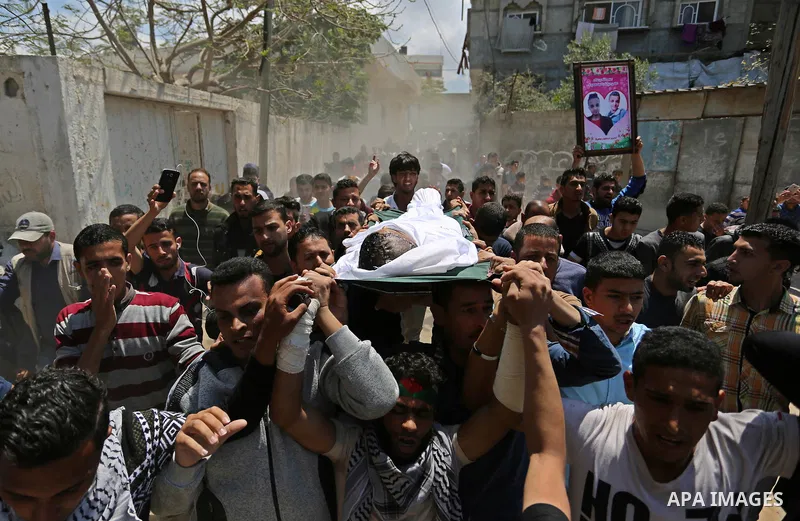 Mourners carry the body of a Palestinian deaf Tahreer Wahba, 18, who was died of from his injuries after being shot in the head by Israeli security forces during clashes on April 6, during his funeral in Khan Yunis, in t...
