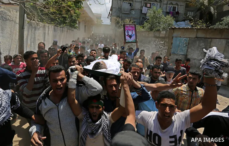 Mourners carry the body of a Palestinian deaf Tahreer Wahba, 18, who was died of from his injuries after being shot in the head by Israeli security forces during clashes on April 6, during his funeral in Khan Yunis, in t...