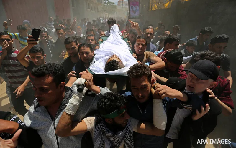 Mourners carry the body of a Palestinian deaf Tahreer Wahba, 18, who was died of from his injuries after being shot in the head by Israeli security forces during clashes on April 6, during his funeral in Khan Yunis, in t...