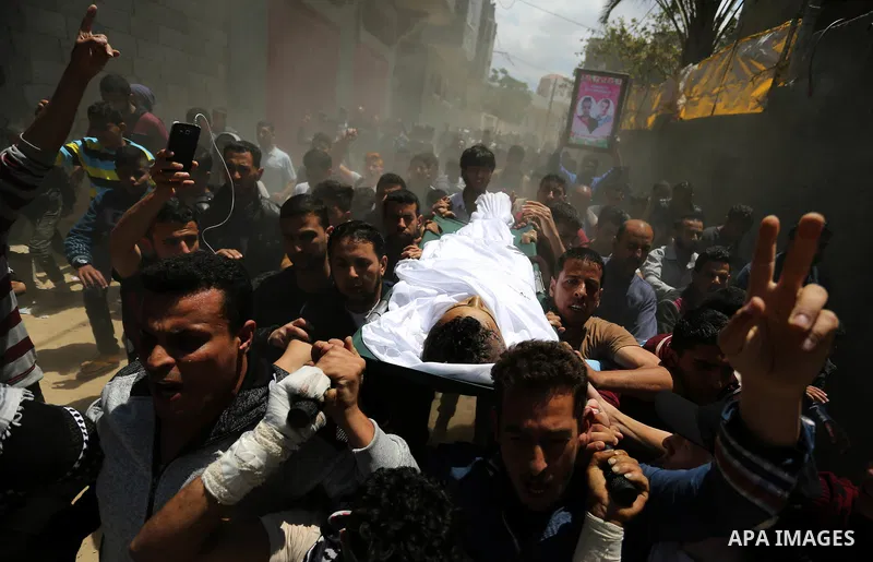 Mourners carry the body of a Palestinian deaf Tahreer Wahba, 18, who was died of from his injuries after being shot in the head by Israeli security forces during clashes on April 6, during his funeral in Khan Yunis, in t...