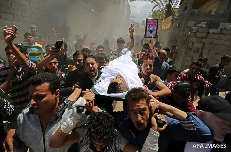 Mourners carry the body of a Palestinian deaf Tahreer Wahba, 18, who was died of from his injuries after being shot in the head by Israeli security forces during clashes on April 6, during his funeral in Khan Yunis, in t...