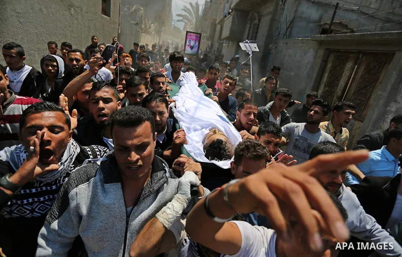 Mourners carry the body of a Palestinian deaf Tahreer Wahba, 18, who was died of from his injuries after being shot in the head by Israeli security forces during clashes on April 6, during his funeral in Khan Yunis, in t...