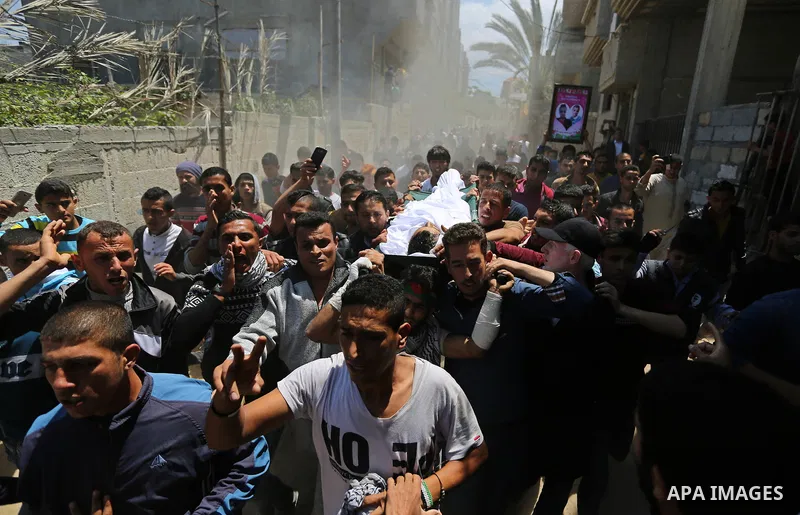 Mourners carry the body of a Palestinian deaf Tahreer Wahba, 18, who was died of from his injuries after being shot in the head by Israeli security forces during clashes on April 6, during his funeral in Khan Yunis, in t...