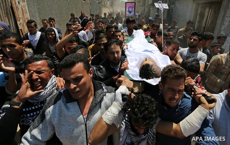 Mourners carry the body of a Palestinian deaf Tahreer Wahba, 18, who was died of from his injuries after being shot in the head by Israeli security forces during clashes on April 6, during his funeral in Khan Yunis, in t...