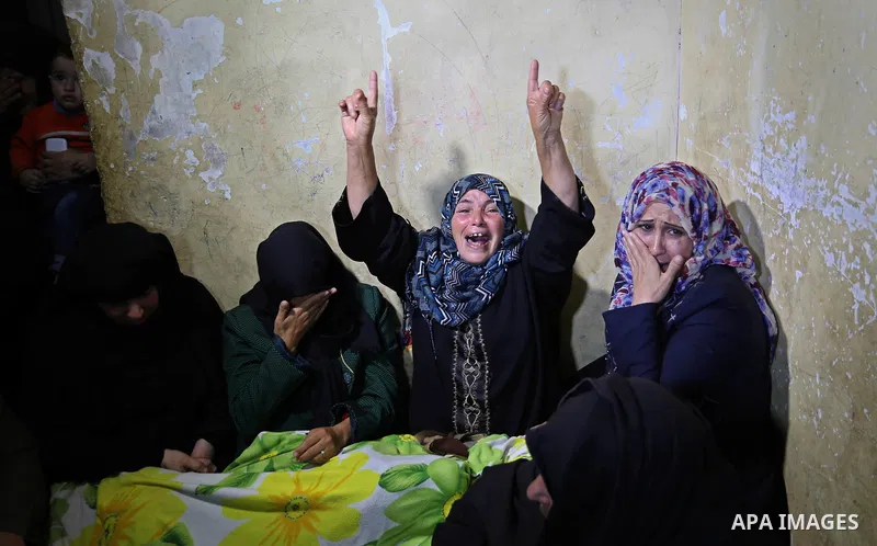 Relatives of a Palestinian deaf Tahreer Wahba, 18, who was died from his injuries after being shot in the head by Israeli security forces during clashes on April 6, mourn over his body during his funeral in Khan Yunis, i...