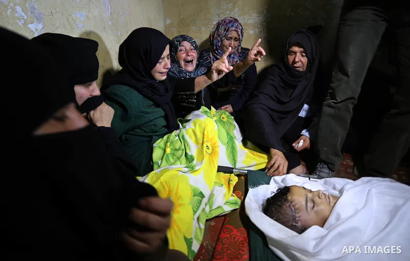 Relatives of a Palestinian deaf Tahreer Wahba, 18, who was died from his injuries after being shot in the head by Israeli security forces during clashes on April 6, mourn over his body during his funeral in Khan Yunis, i...