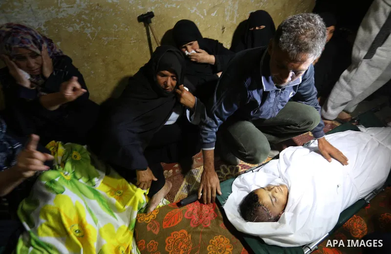 Relatives of a Palestinian deaf Tahreer Wahba, 18, who was died from his injuries after being shot in the head by Israeli security forces during clashes on April 6, mourn over his body during his funeral in Khan Yunis, i...