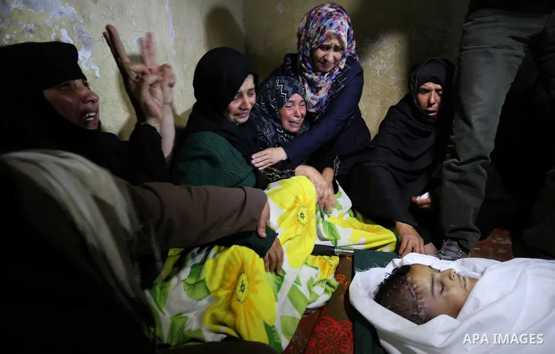 Relatives of a Palestinian deaf Tahreer Wahba, 18, who was died from his injuries after being shot in the head by Israeli security forces during clashes on April 6, mourn over his body during his funeral in Khan Yunis, i...